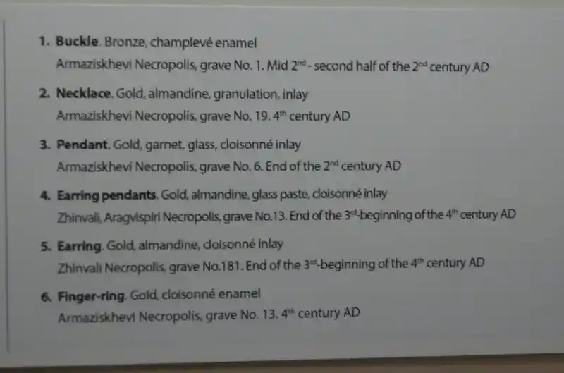 Gold pendant with a four-pointed flower-like cross in the middle